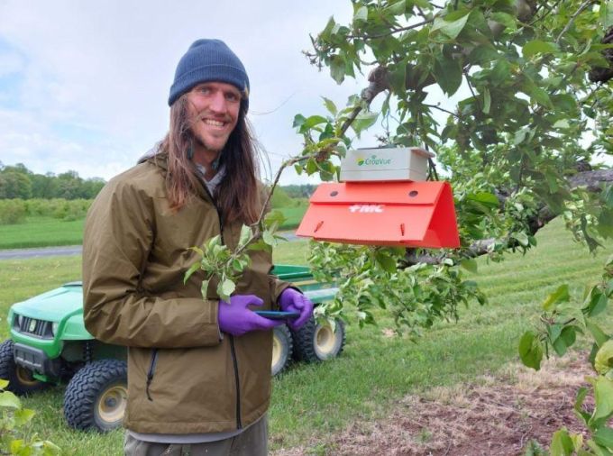 Tyler and his trap in an orchard