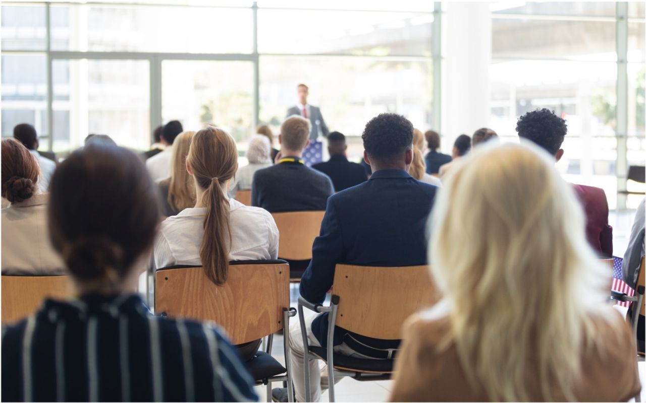 People sitting in the audience as a conference listening to a speaker.