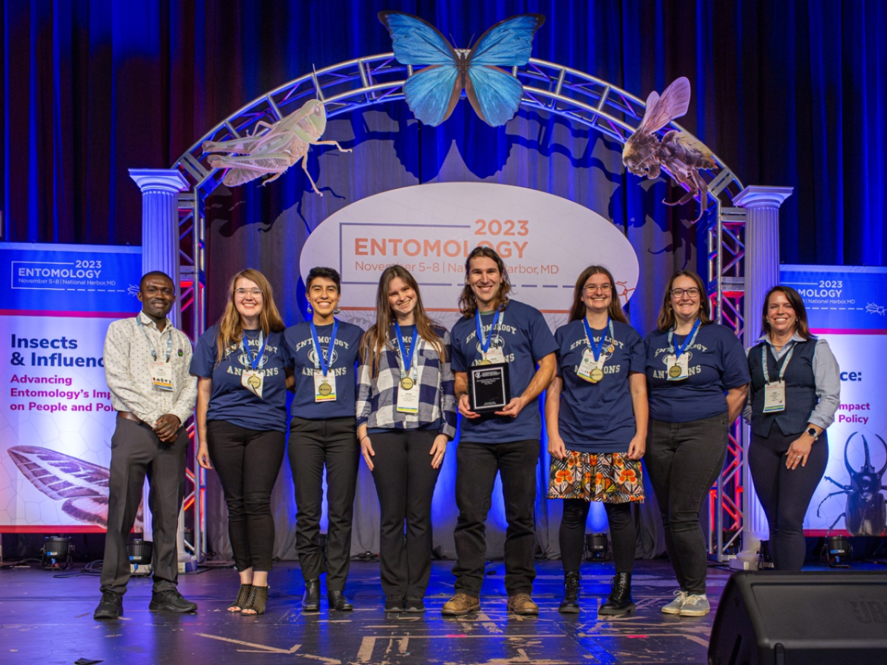 group of people stand on a stage facing the camera